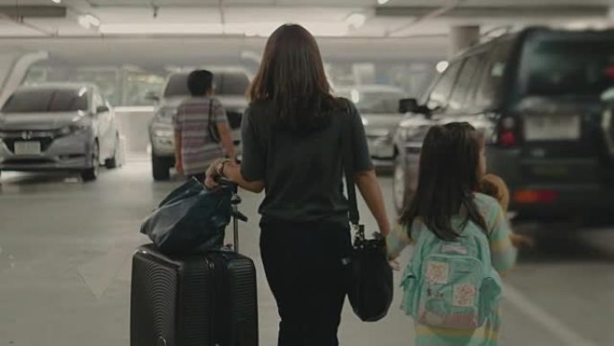 带着行李在停车场散步的亚洲旅行者