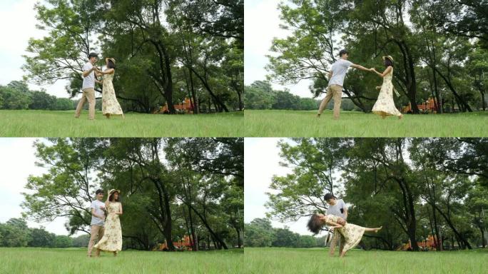 浪漫的亚洲夫妇带着快乐的情感在花园里跳舞。人们有生活方式，放松情感的概念。
