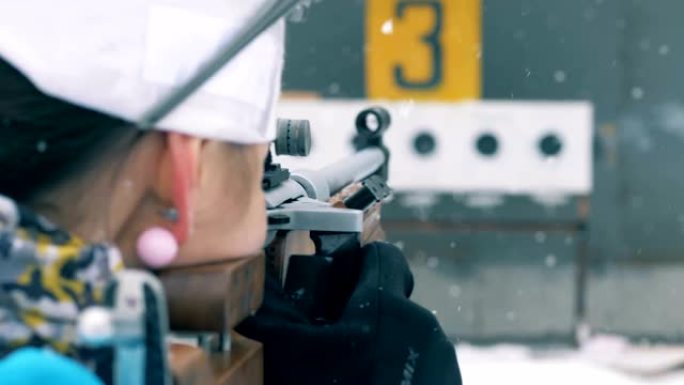一名运动员在降雪中的冬季两项射击比赛