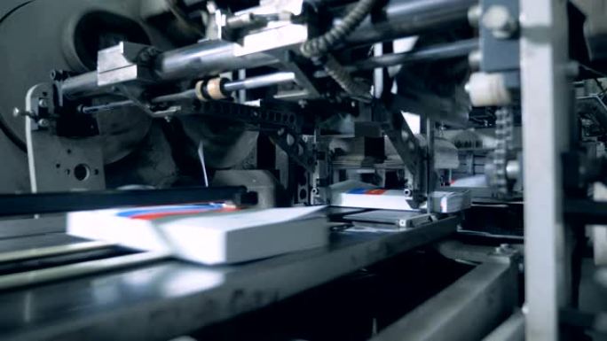 工厂机器正在切断印刷书籍的边缘