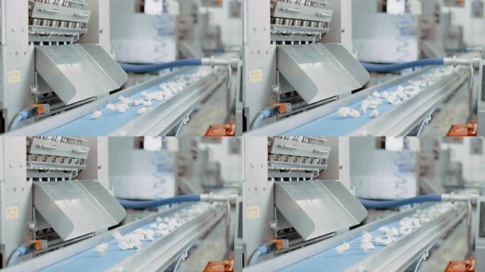 饺子厂的自动机器生产过程。新鲜的生水球落在传送带上。在食品工厂运行的工业机械。