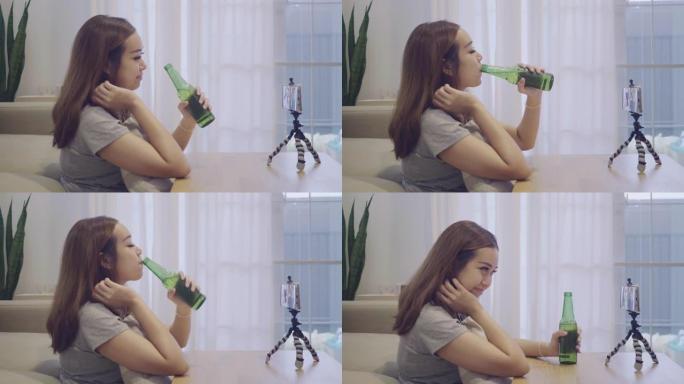 亚洲女人在家里和男朋友的视频会议上喝啤酒。