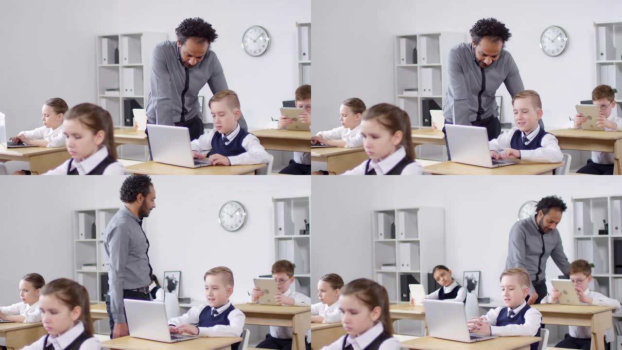 美国黑人老师在计算机课上检查学生