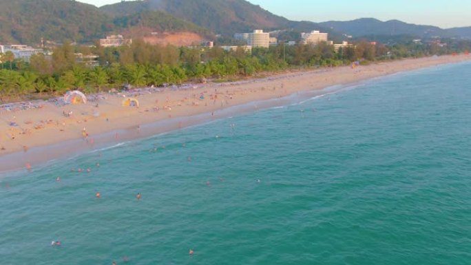卡隆海滩日落，人们在海中游泳，享受日光浴，度假海滩。由于检疫新型冠状病毒肺炎，在关闭海滩前几天。空中