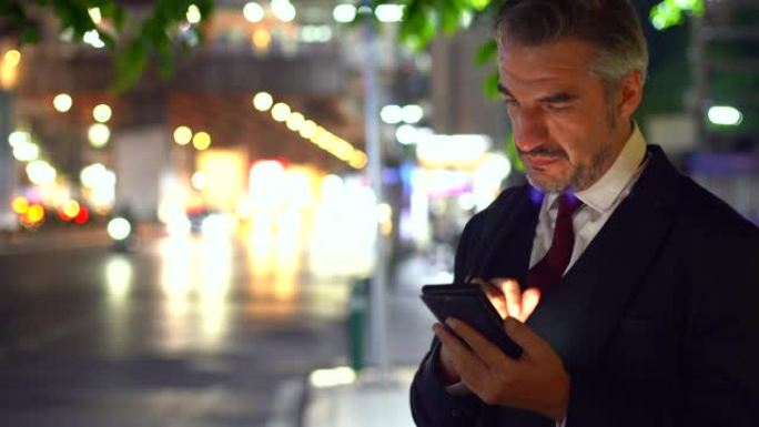 商人在晚上网上预订出租车。商人在晚上用手机在街上叫出租车。