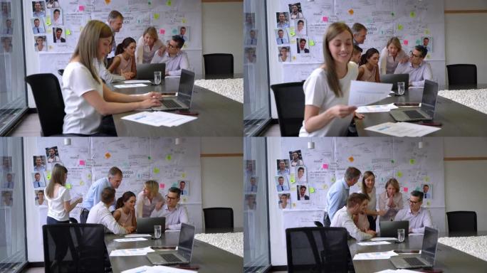 美丽的女人在笔记本电脑上工作，然后在会议期间将文件带到团队