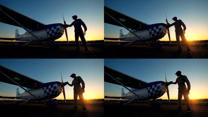 男飞行员擦拭飞机的螺旋桨，侧视图。