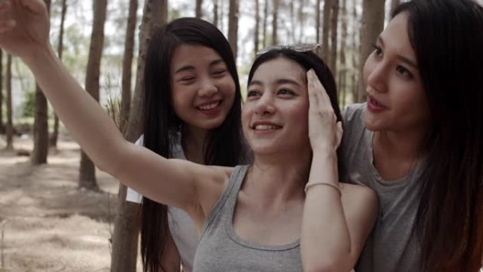 青少年女性使用智能手机vlog视频并生活在社交媒体中，一群年轻的亚洲朋友在森林中露营。夏季假期的冒险