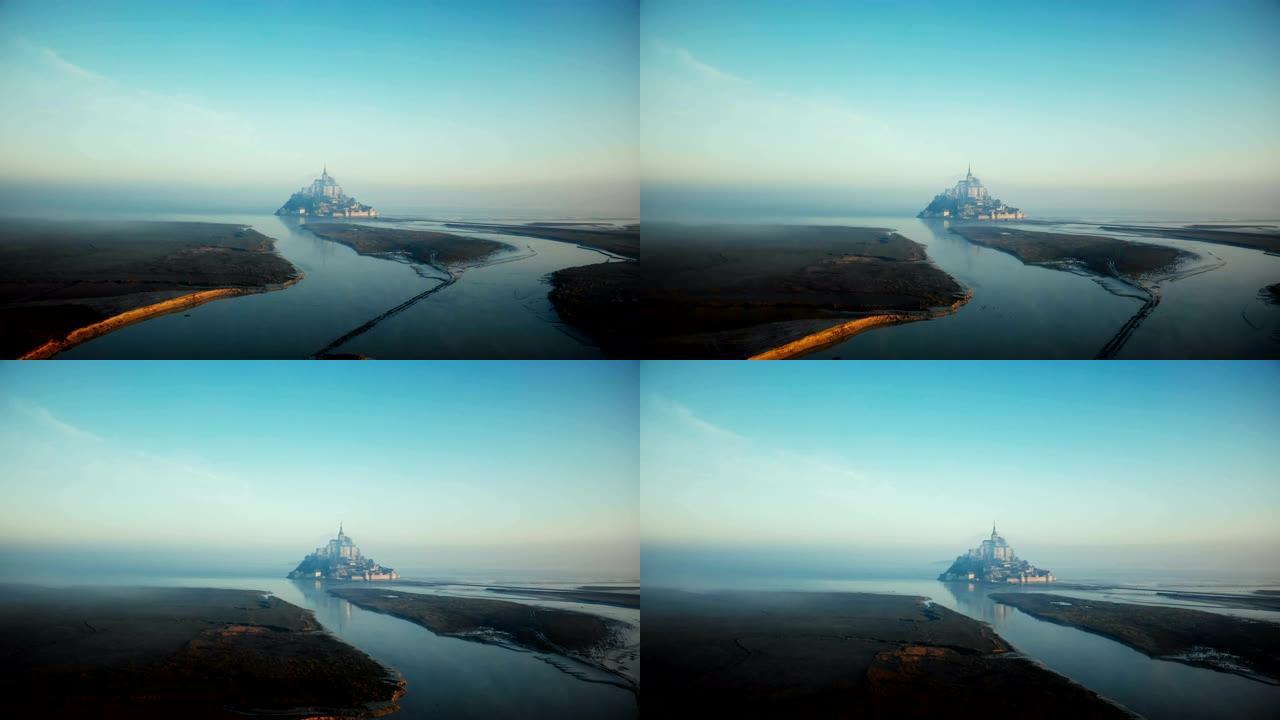 在史诗般的日出高潮，法国标志性的岛屿要塞地标城堡，无人机飞向雾蒙圣米歇尔山