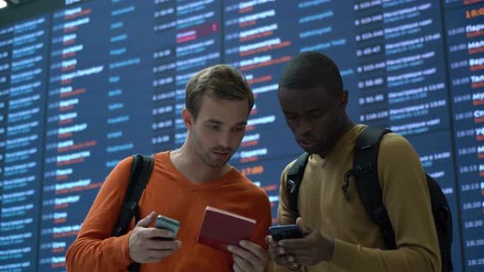 机场上的各种朋友在聊天时看着智能手机上的护照和登机牌