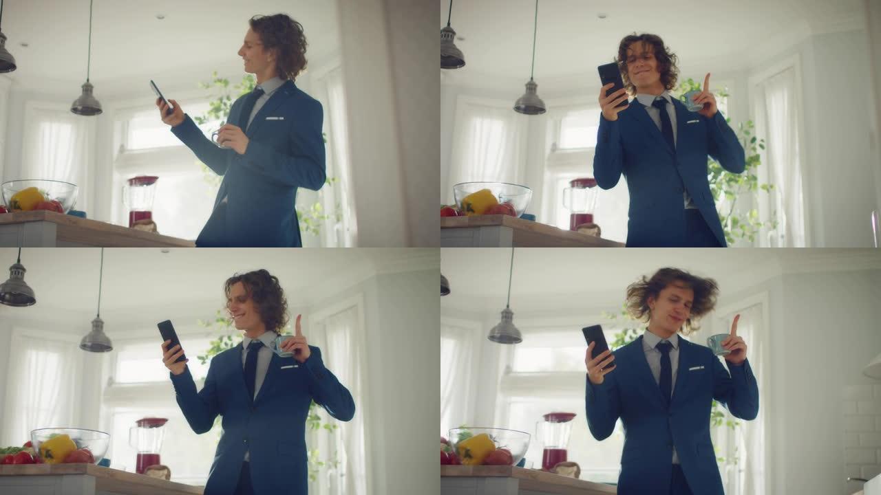 穿着蓝色西装的长发快乐的年轻人在家里跳舞。他正在手机上听音乐。精力充沛的人在厨房里使用智能手机，里面