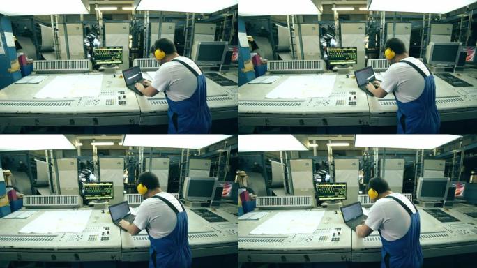 工厂工人用笔记本电脑操作排版设备