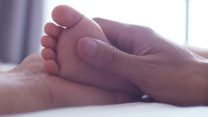母亲抱着婴儿的脚温馨抚摸脚丫小脚丫
