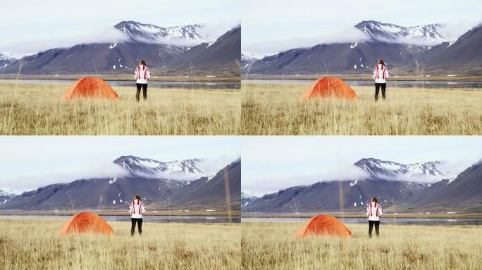 WS妇女站在冰岛偏远山区的露营帐篷外