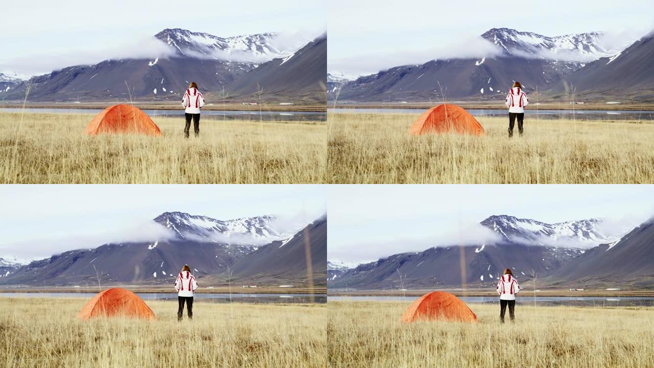 WS妇女站在冰岛偏远山区的露营帐篷外