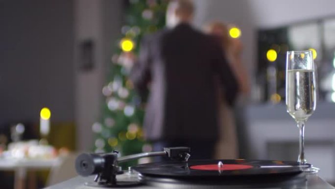 无法辨认的夫妇在圣诞节在家中跳舞到黑胶唱片