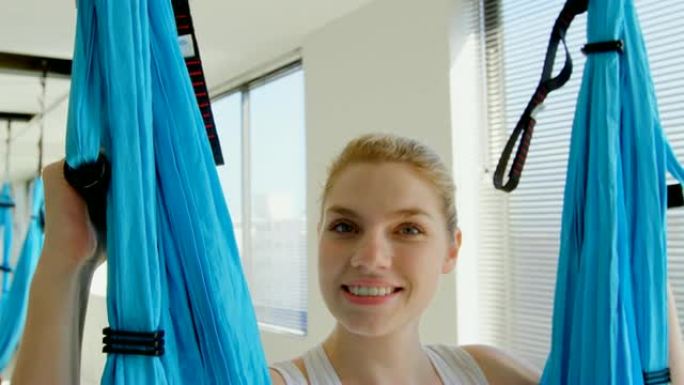 女人坐在4k健身工作室的吊床秋千上