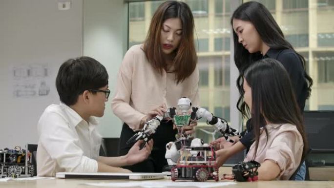 年轻的亚洲创意工程师会议，在笔记本电脑车间为协作通用机器人编程。有技术或创新概念的人。