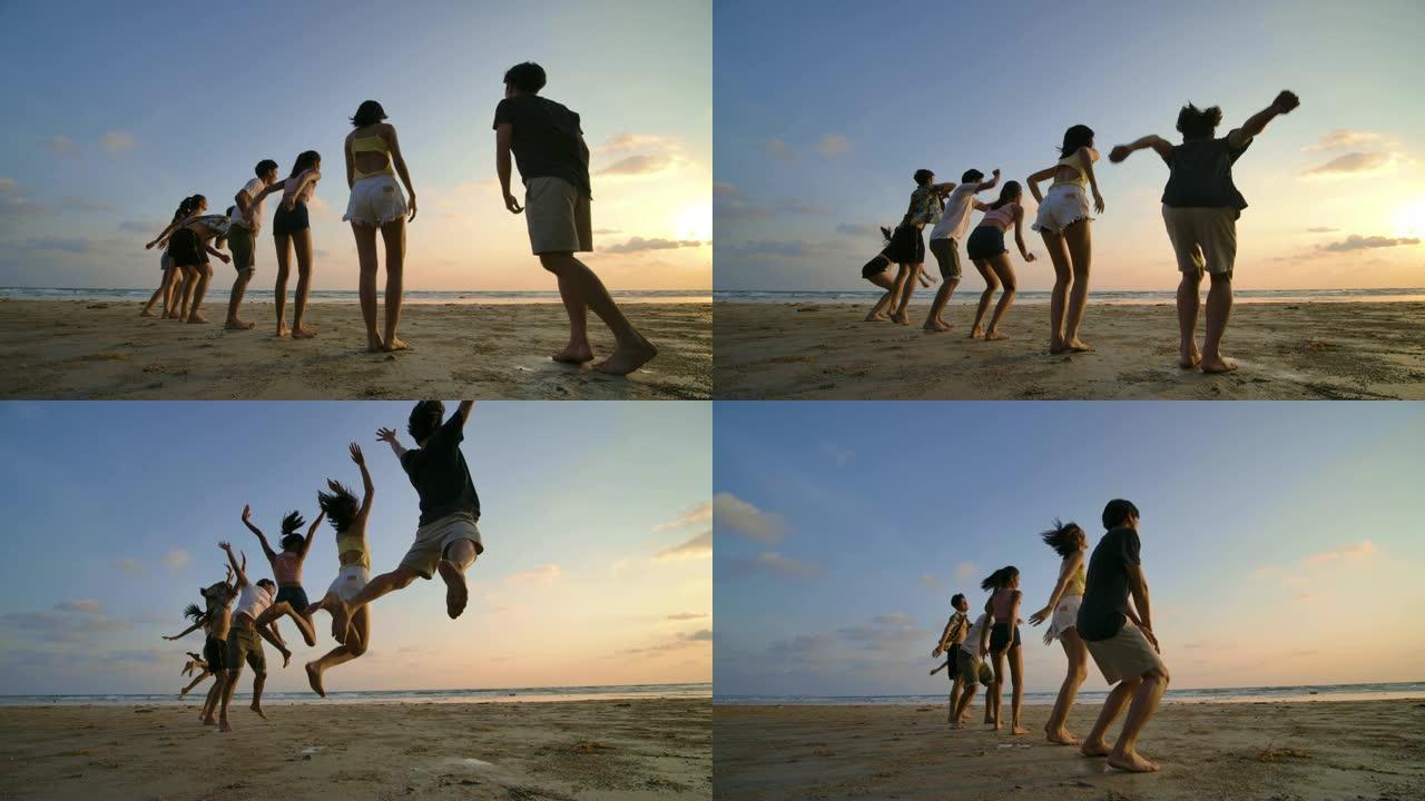 日落时分，朋友们在海滩上跳跃的剪影带着快乐的情感。4k分辨率。慢动作镜头。
