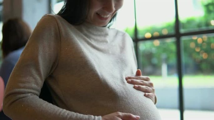 孕妇轻轻地抚摸她的肚子