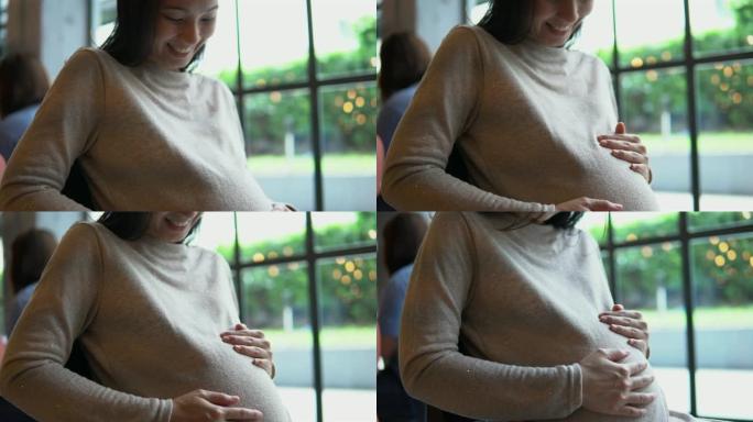 孕妇轻轻地抚摸她的肚子
