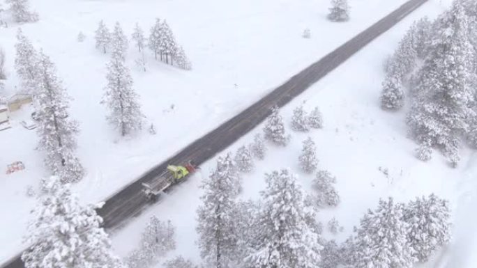 空中: 扫雪车清洁穿过森林的乡间小路。