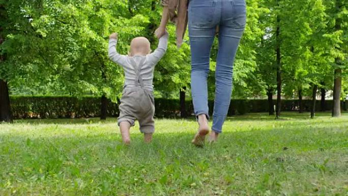 母亲和男婴赤脚在草地上行走