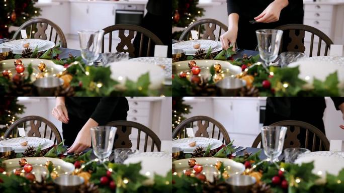 一名妇女的中间部分，在装饰圣诞节晚餐的餐桌上摆放银色餐具，选择性聚焦