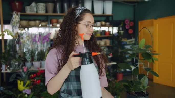 微笑的年轻花店使用瓶装喷雾器照顾绿色植物浇水