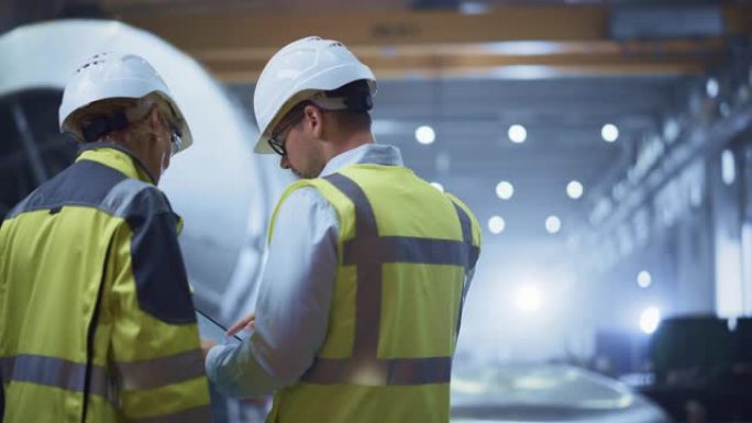 Two Heavy Industry Engineers Stand in Pipe Manufac