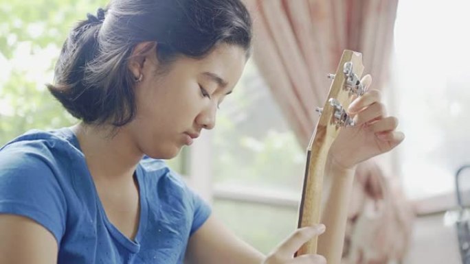 亚洲青少年女孩调音四弦琴乐器