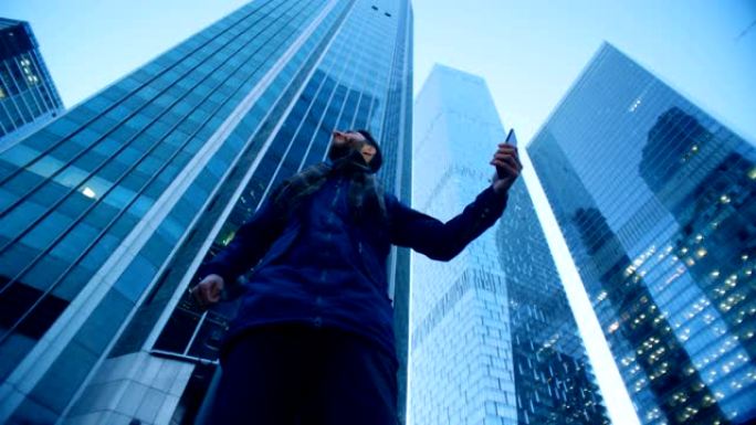 一名男子环顾摩天大楼，制作视频。史诗电影相机拍摄。