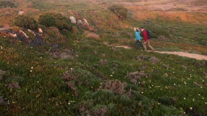 高年级高加索夫妇在山顶的小径上徒步旅行