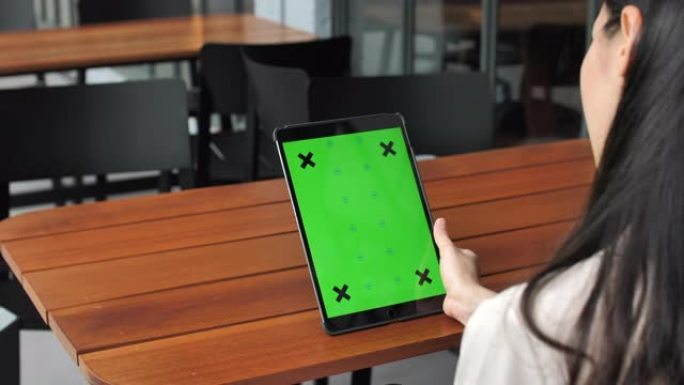 使用带有绿色屏幕的数字平板电脑拍摄女性的肩膀