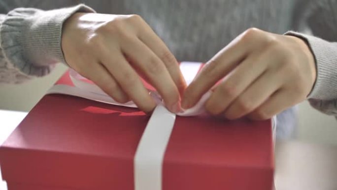 礼品包装，女人为圣诞节活动绑白丝带蝴蝶结