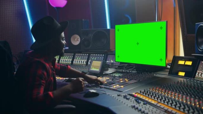 在音乐唱片工作室工作的时尚音频工程师/制作人的肖像，使用绿屏计算机，混音器板，控制台来创作新歌。创意