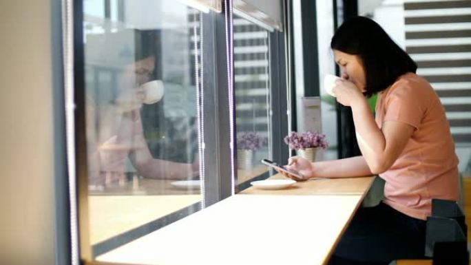 女人使用智能手机在咖啡馆喝咖啡，慢动作