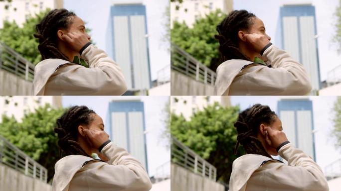 城市4k中戴着耳机的年轻非洲裔美国妇女的侧视图