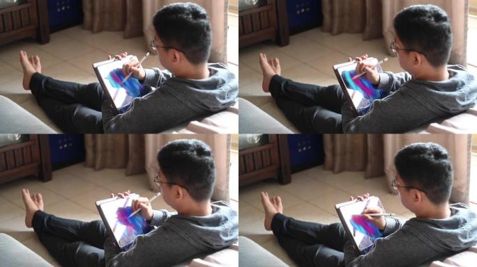 一名亚洲中国中年男子在家中使用数字平板电脑进行drraw