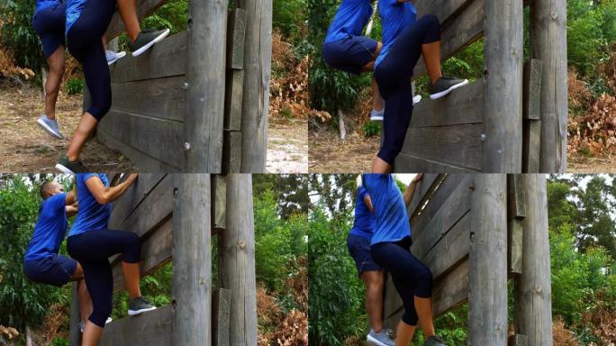 情侣climbing a wooden wall during障碍比赛