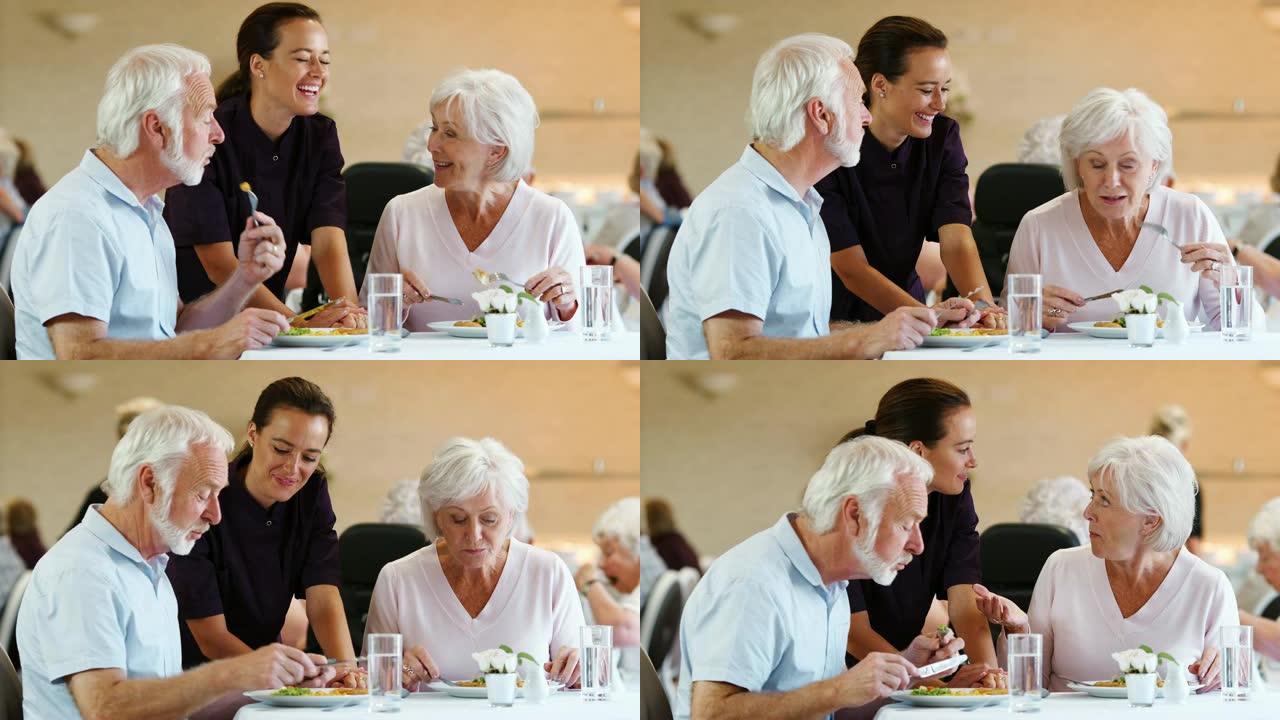 高级夫妇在养老院吃饭并与看护人交谈
