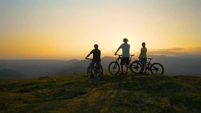 慢动作: 一群骑自行车的fit游客观察金色的日出。