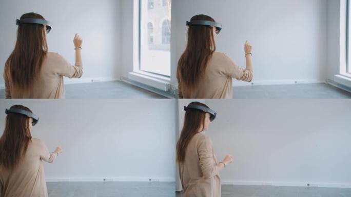 戴着全息增强现实眼镜的年轻时髦女人站在空荡荡的办公室里并绘制地图。她在空间里移动虚拟碎片。房间有视频