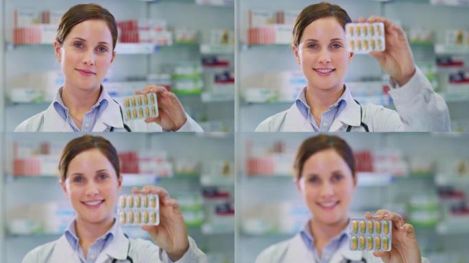 一名年轻女性药剂师顾问在镜头前微笑着展示一包药丸的慢镜头