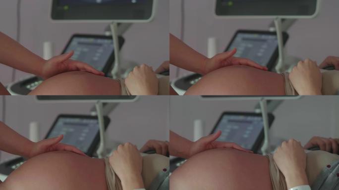 护士手的真实特写镜头在医院的产房分娩时，在宫缩过程中抚摸着一名年轻孕妇的腹部。