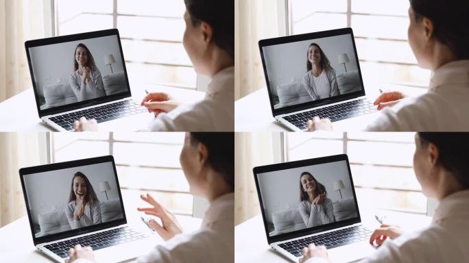 年轻快乐的女人视频在笔记本电脑屏幕上呼叫快乐的朋友