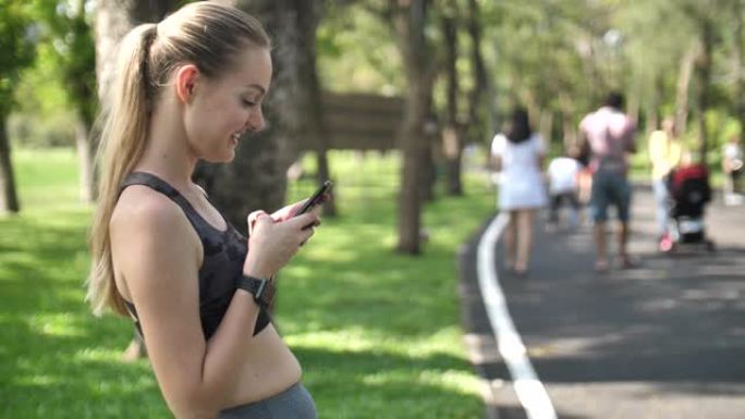 运动运动女性在公园使用智能手机