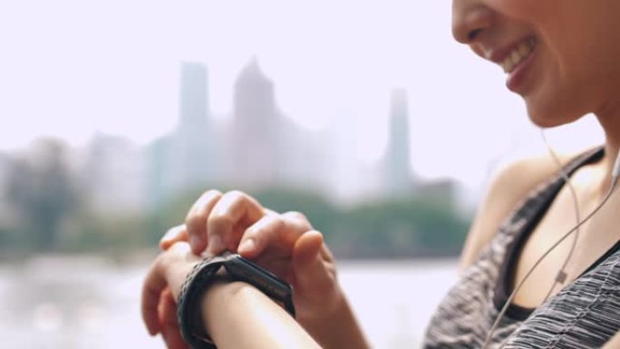 女人使用智能手表检查脉搏，监控她在智能手表上的跑步表现