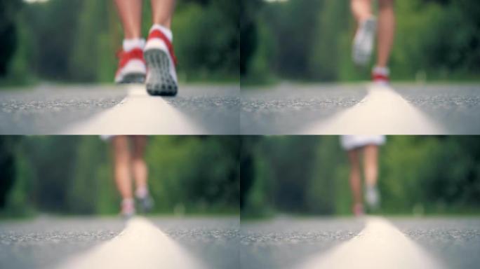 穿着运动鞋的女性脚在道路表面的特写
