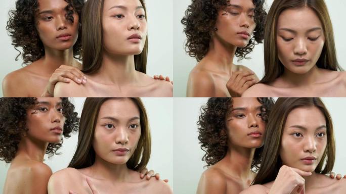 非洲和亚洲妇女摩擦皮肤与美丽的皮肤护理产品在白色的背景。